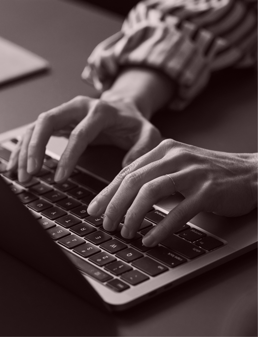 Hands typing on a laptop.